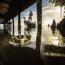 Angler casting beneath a dock from a bass boat with Ultrex on the bow