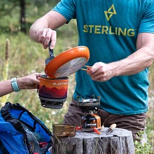 Spooning a cooked meal from the Jetboil skillet into the Jetboil MiniMo