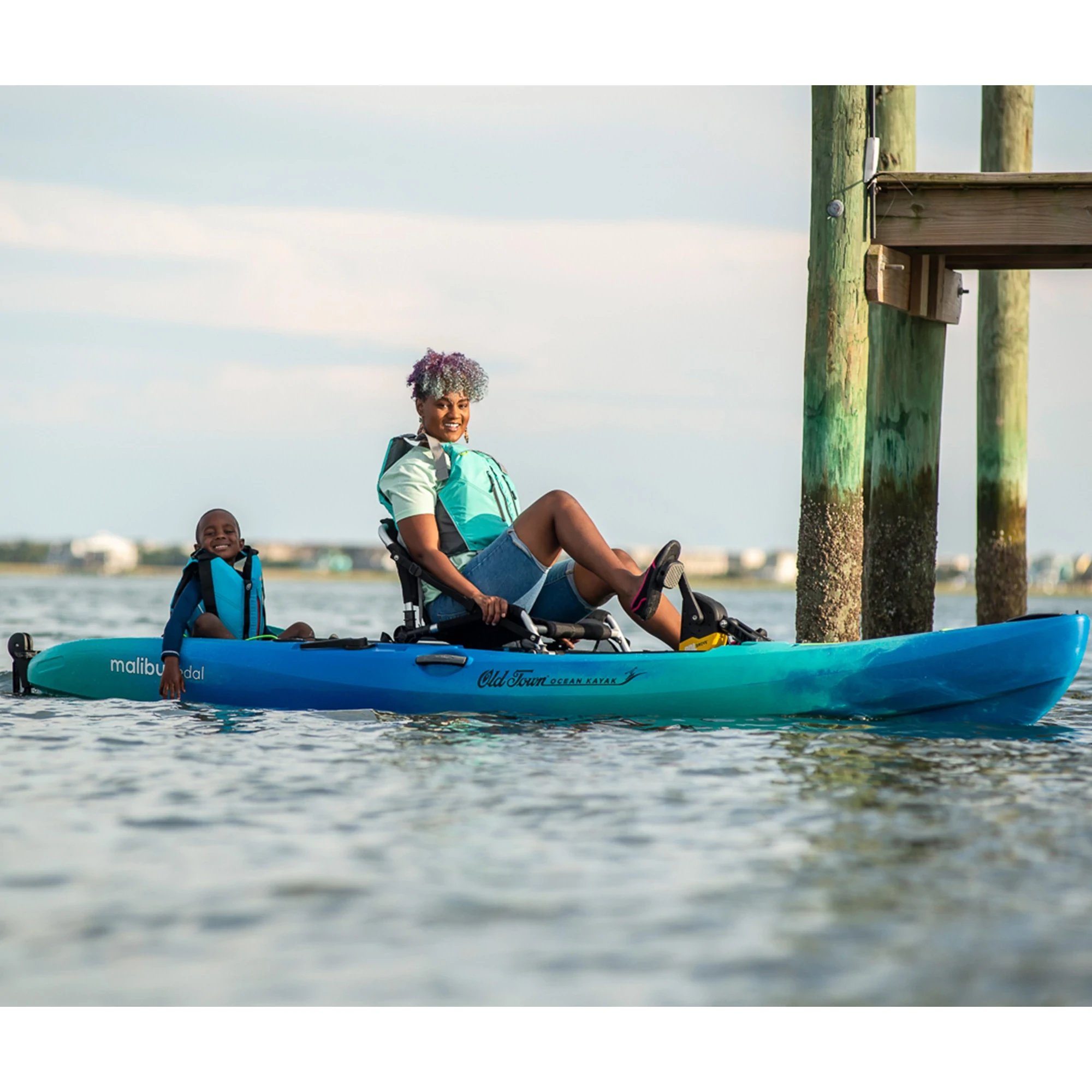 Woman with child pedaling in the Old Town Ocean Kayak Malibu PDL kayak