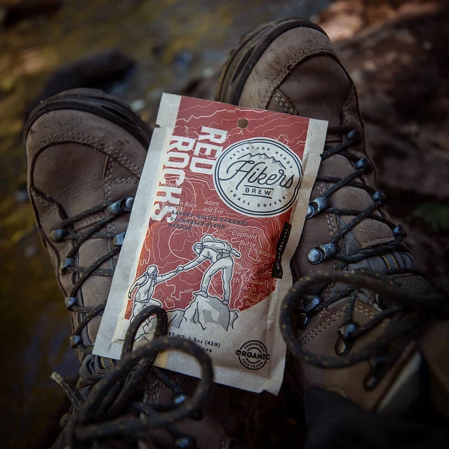 Close up of Hikers Brew Red Rocks trail coffee packet and hiking boots