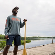 Man with paddle in hand wearing Old Town Sportsman LS Performance Hoodie