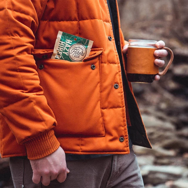 Man with Hikers Brew Hazy Hiker Trail Coffee packet and a mug