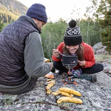 Couple enjoying a hot meal from the Ceramic Cook Pot on the Mighty Mo Stove