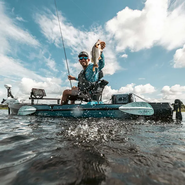 Holding up a fish caught while in the Old Town Sportsman 120 Pro fishing kayak