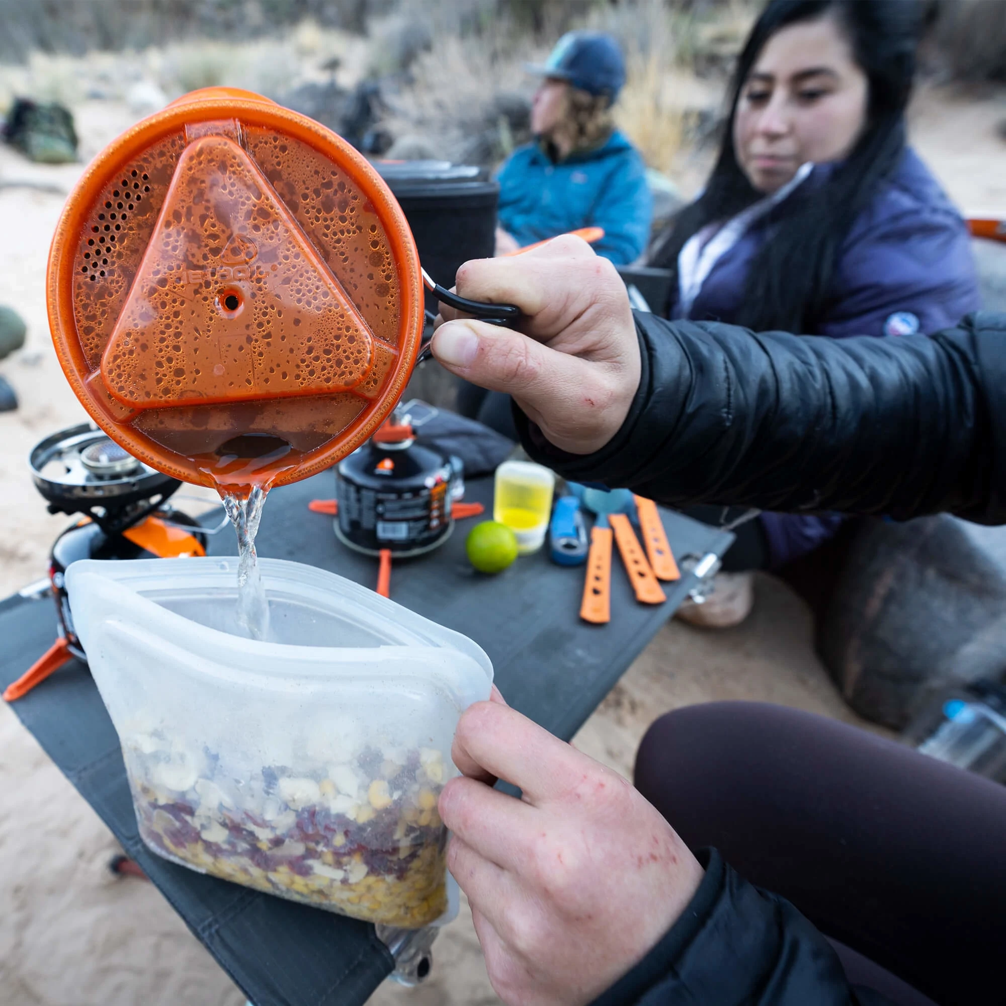 Pouring hot water from a Jetboil cooking system in to a stasher bag filled with food