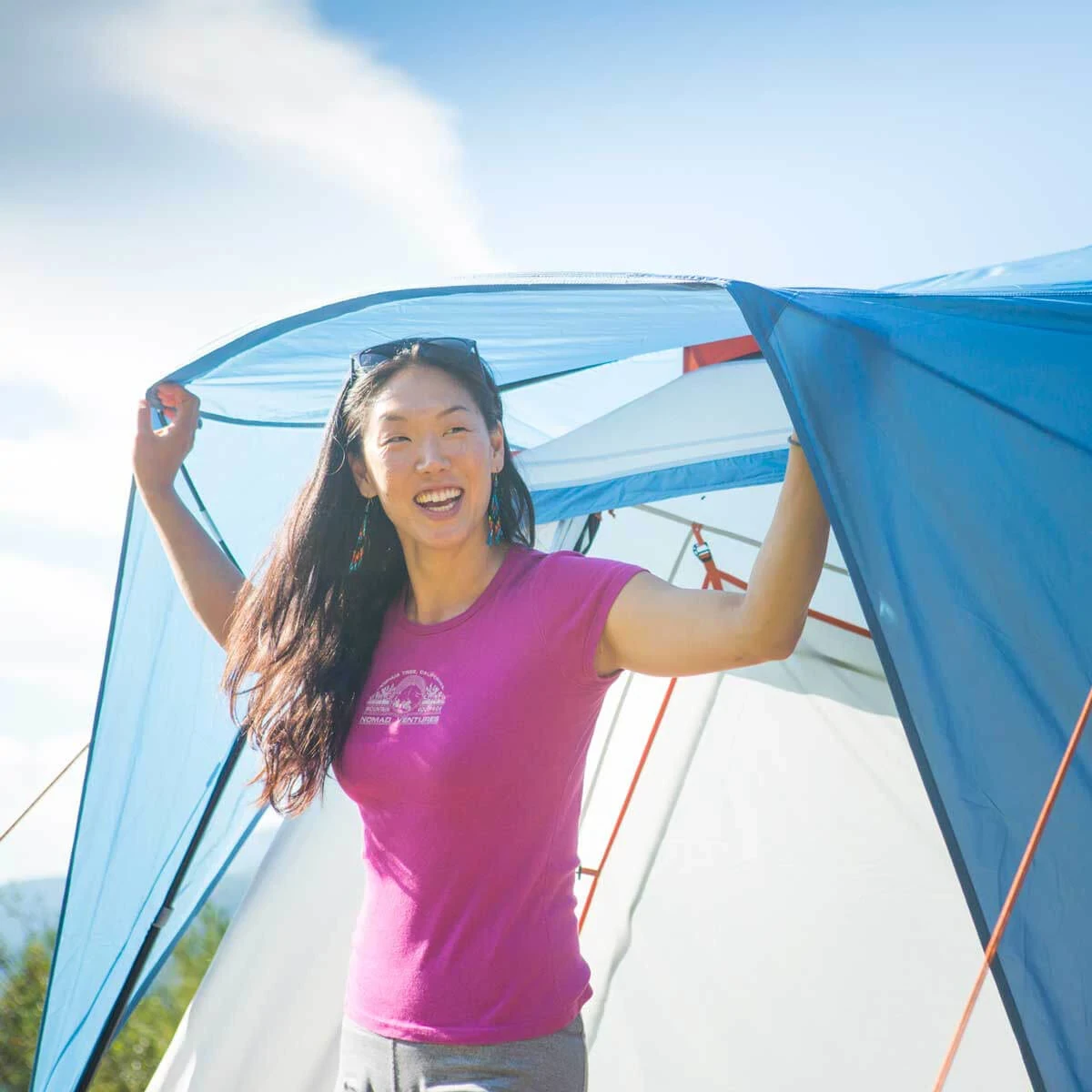 Woman standing under extended fly coverage over the door of the Copper Canyon LX tent