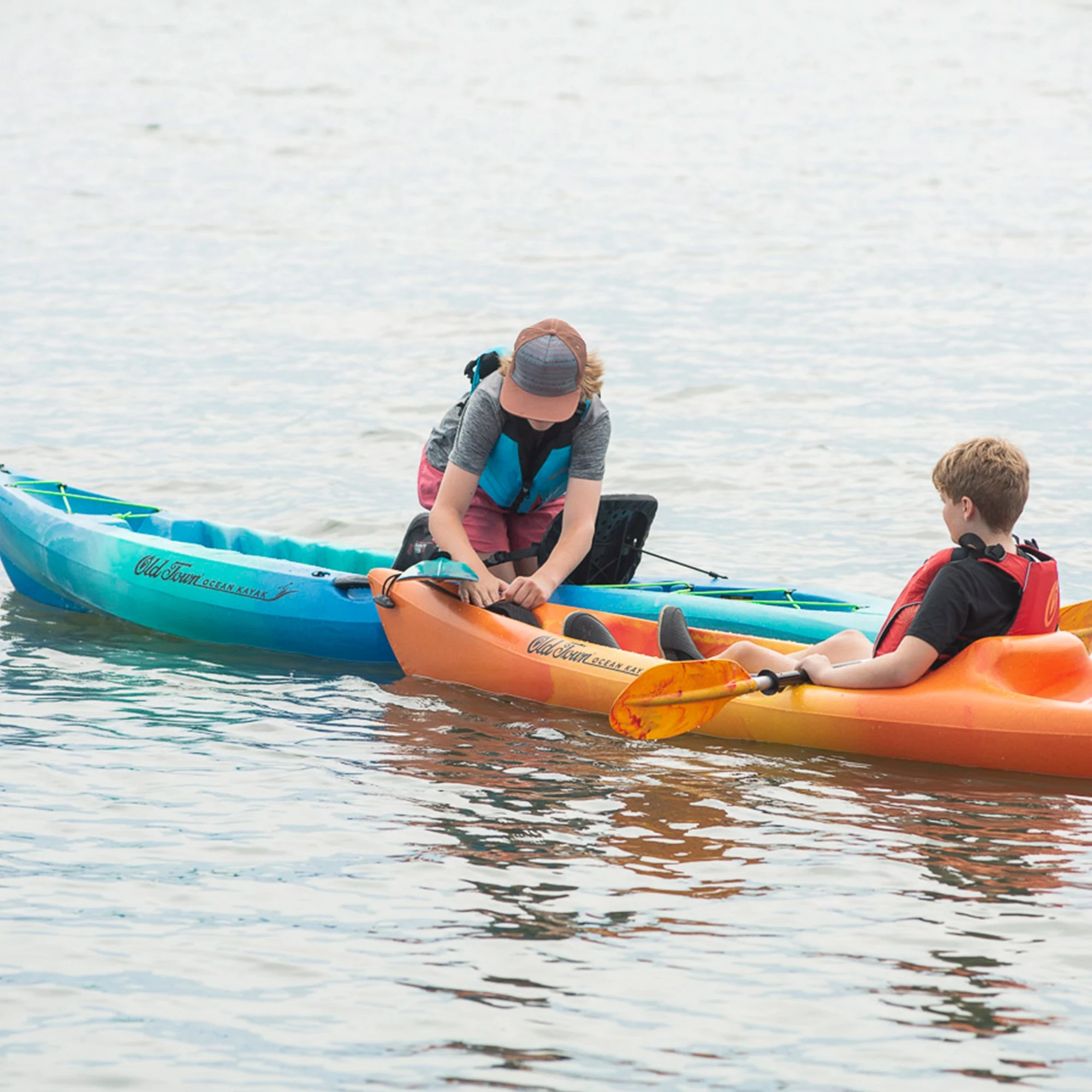 Two children in their Ocean Kayak Banzai and Malibu 9.5 kayaks
