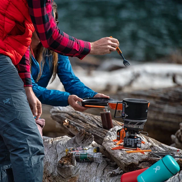 Campers cooking outdoors with the MiniMo Cooking System