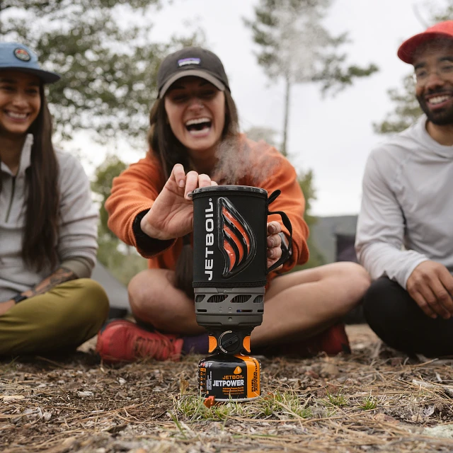 Friends gathered around a steaming Jetboil Flash 1.0L cooking system