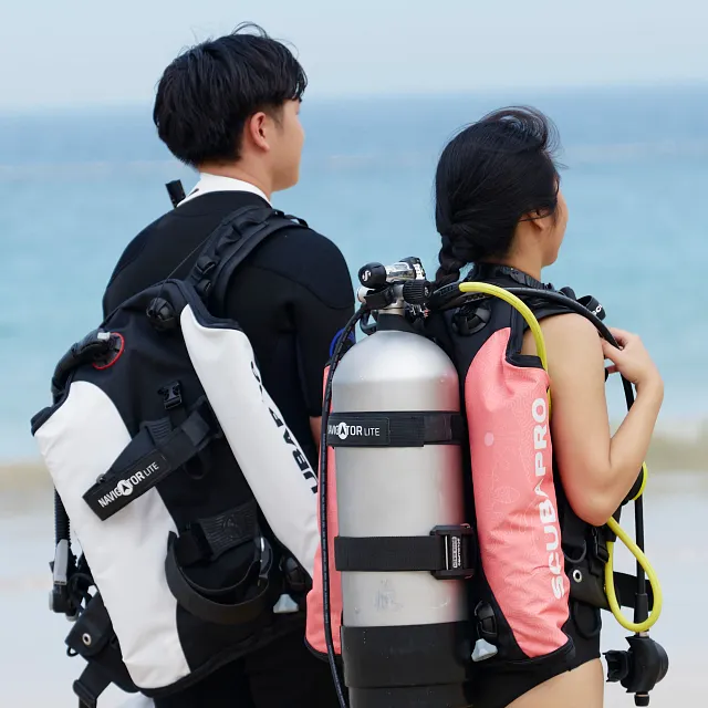 Two divers wearing Navigator Lite Weight Pocket on Navigator Lite BCD standing by the water before dive
