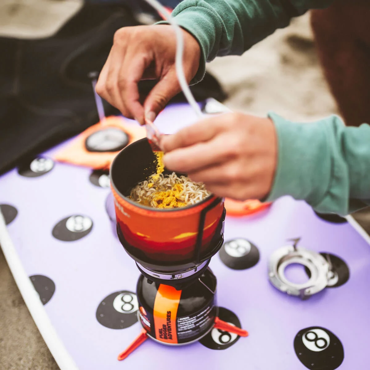 Pouring ramen seasoning packet into cooked ramen in the Jetboil MiniMo