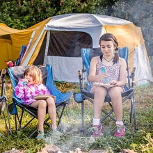 Kids sitting in Eureka! chairs by campfire