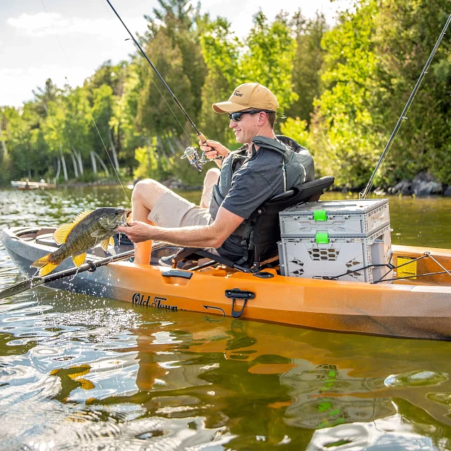 Holding caught fish in Old Town Sportsman 120 fishing kayak