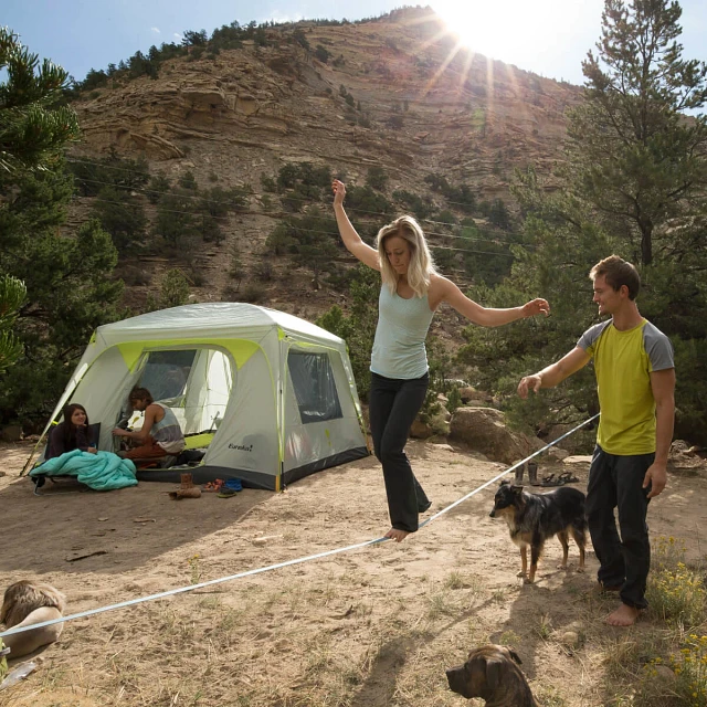 People using a slackline with the Jade Canyon 6 tent in the background