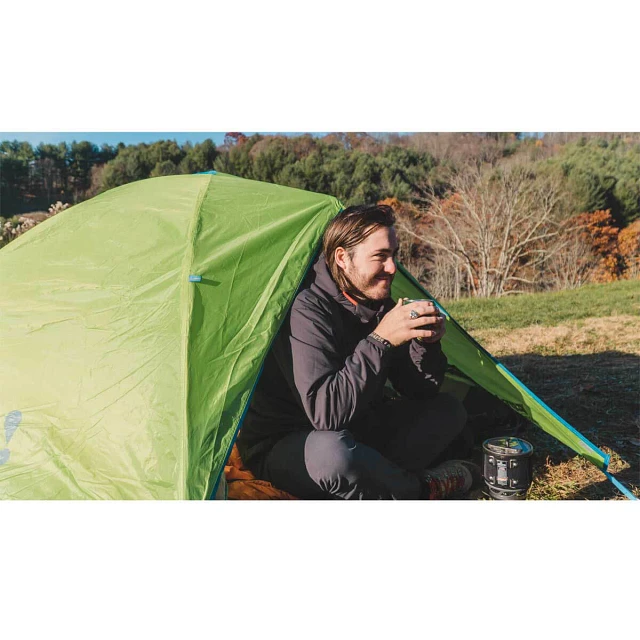 Man drinking coffee in front of a Midori tent