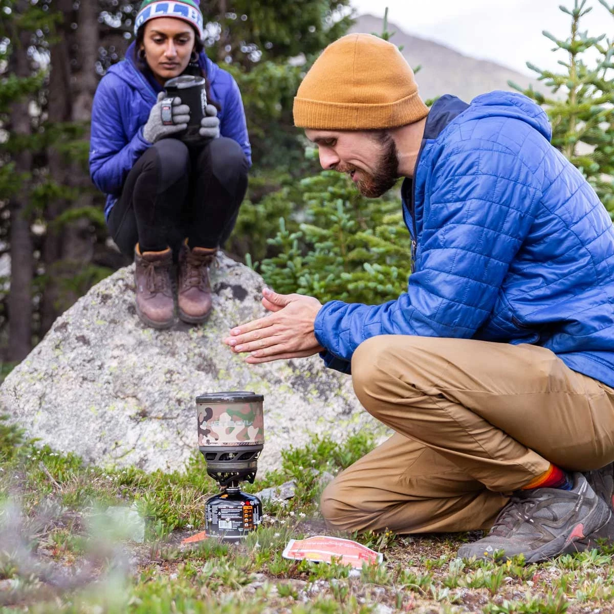 Couple using the MiniMo Cooking System outdoors